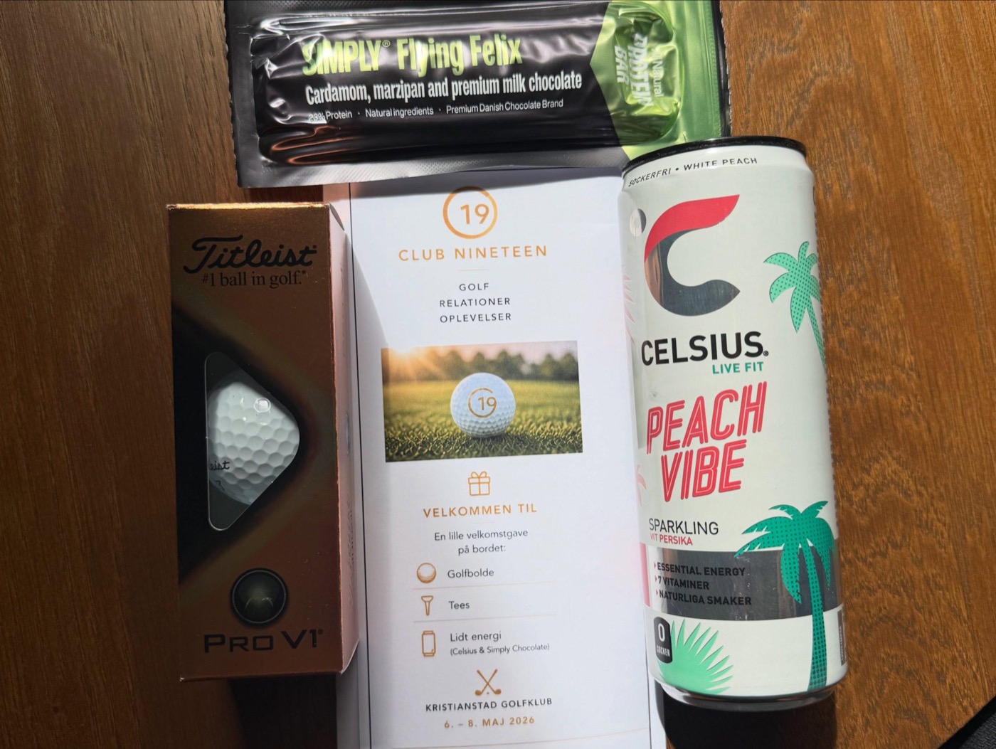 Velkomstgave med Club Nineteen-kort og golfbolde på et bord ved et event